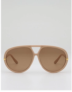 Detail view of aviator sunglasses with beige frames and golden metal temple hinges