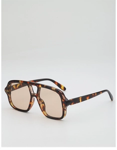 Detail of tortoise pilot sunglasses featuring double bridge and brown lenses on white back