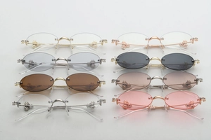 Detailed close-up of luxury oval rimless sunglasses with rhinestone-set metal hinges