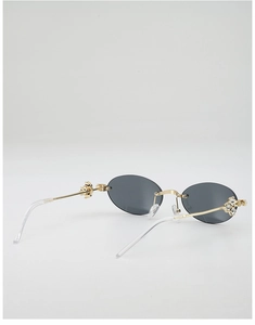 Close-up of vintage oval rimless sunglasses with gold temples and crystal flower details
