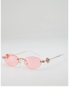 Detail view of pink rimless oval sunglasses with crystal flower accents on rose gold metal