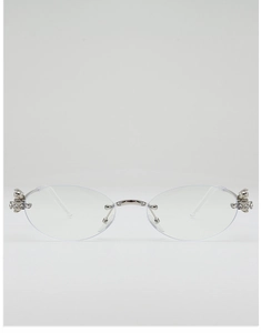 Detail of silver oval rimless sunglasses featuring a rhinestone-studded Saturn orb hinge