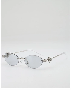 Macro view of rimless oval sunglasses with silver metal temples and rhinestone floral accents