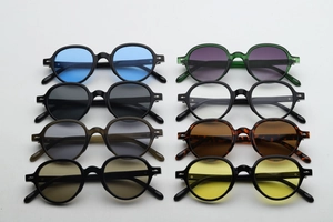 Flat lay of vintage round sunglasses in eight vibrant colors with classic silver diamond rivets