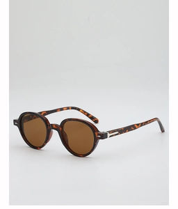 Detailed close-up of retro round tortoiseshell sunglasses with brown lenses and silver accents