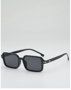 Detail of square black sunglasses with dark lenses and silver metal corner accents