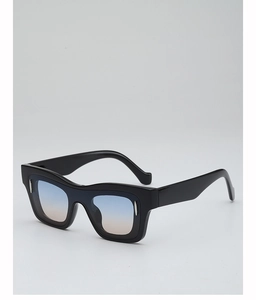 Macro detail of black square sunglasses featuring blue-pink gradient lenses and wave frame