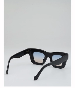 Macro side view of thick black square sunglasses with blue and orange gradient lenses