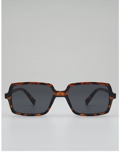 Detail of tortoise shell square sunglasses with dark grey lenses in a studio setting