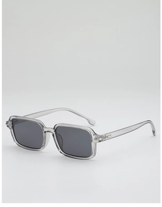 Close-up of translucent grey rectangular sunglasses with dark lenses and metal hinge detail