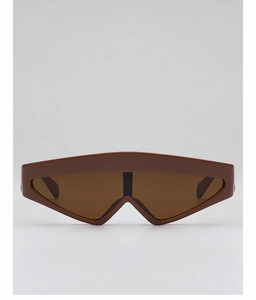 Détail de lunettes de soleil futuristes oversize marron foncé avec découpe sur le pont