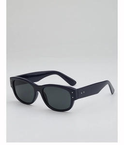 Detail view of vintage sunglasses featuring dark frames and decorative silver metal studs