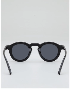 Detail view of retro round sunglasses with black frames and dark grey lenses for sun protection