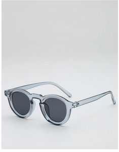 Close-up of retro round sunglasses with translucent grey-blue frame and dark grey lenses