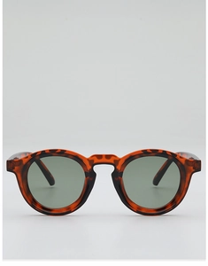 Close-up of retro round sunglasses with tortoise shell texture and dark green lenses