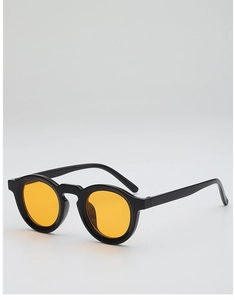 Detail of retro round sunglasses featuring a black acetate frame and yellow tinted lenses
