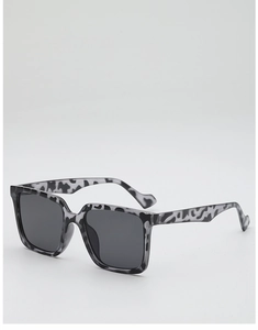 Detail view of bold tortoiseshell oversized square sunglasses with wide wavy temples