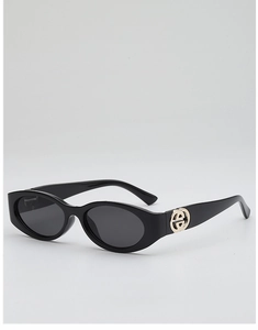 Close-up of oval black sunglasses with gold circular metal hinge detail on the side