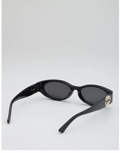Detail view of oval sunglasses with gold interlocking logo and CV5039 code on the temple