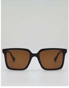 Close-up of square oversized sunglasses with black frames and brown amber lenses
