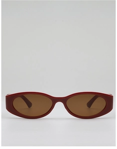 Flat lay of red oval frame sunglasses with brown tinted lenses in retro street style
