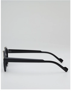 Detail of sleek black sunglasses frame featuring gold metal accents and ergonomic temples