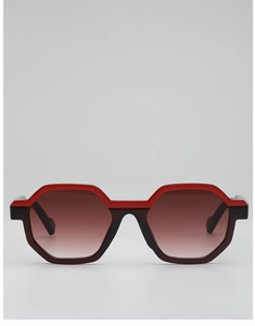 Front detail of geometric sunglasses featuring a unique red and black dual-layer frame