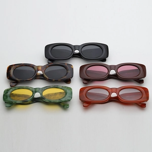 Group view of five retro thick-framed oval sunglasses in various colors and textures