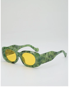 Detail of green marble frame sunglasses with yellow oval lenses and wavy temples