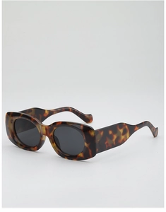 Close-up of tortoise shell pattern oval sunglasses with wavy wide temple design