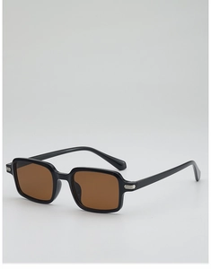 Detail view of retro black square sunglasses with brown lenses and silver metal hinge accents