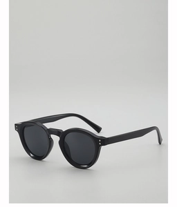 Detail view of black round retro sunglasses with silver rivets and smooth temples