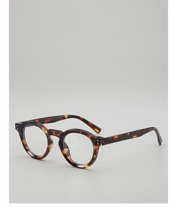 Detail of round tortoiseshell glasses frame with metallic studs and clear lenses