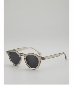 Detailed close-up of translucent grey round frame sunglasses with dark grey lenses