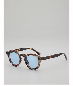 Detail of round tortoiseshell sunglasses with blue lenses and silver rivet accents