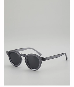 Detail view of round grey translucent frame sunglasses with metallic accents and hinges