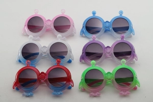 Flat lay of cartoon penguin children's sunglasses in six assorted vibrant colors