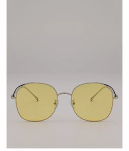 Detail of retro oversized sunglasses with yellow tinted lenses and silver metal frames