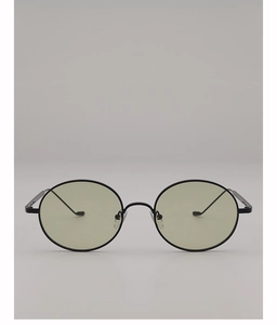 Détail de lunettes de soleil ovales en métal avec verres verts et plaquettes de nez