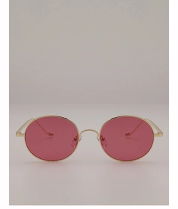 Détail de lunettes de soleil rétro avec verres roses et monture en métal doré fin