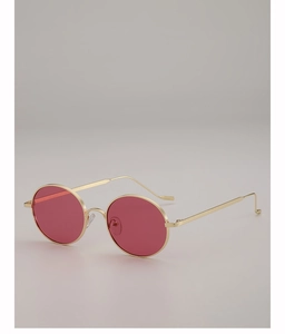 Détail de la monture en métal doré et des verres ovales rouges transparents des lunettes