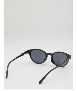 Detail view of black round sunglass frame with glossy finish and metal hinges