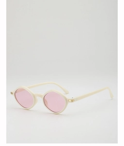 Detail van de crème zonnebril met roze lenzen en gouden metalen accenten op de poot