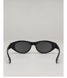 Detail of vintage black oval sunglasses with polished acetate frames and dark grey lenses