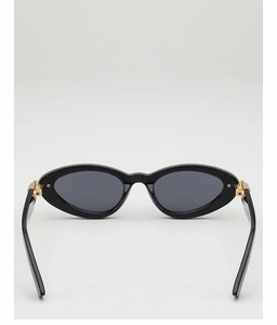 Detail view of oval cat-eye sunglasses featuring golden metal accents on black temples