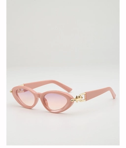 Close-up of pink cat eye sunglasses featuring gold spike hardware and gradient lenses
