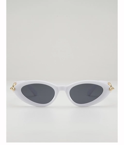 Close-up of cat-eye sunglasses with white frame and gold spiked metal details