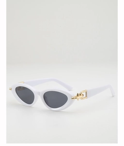 Close-up of white cat-eye sunglasses with gold metal spikes and studs on the temples