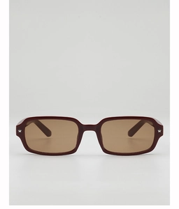 Détail de lunettes de soleil rectangulaires bordeaux avec rivets étoile et verres bruns