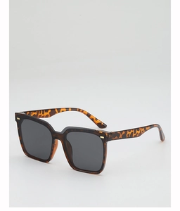 Detail of square oversized tortoiseshell sunglasses with gold metal studs and dark lenses